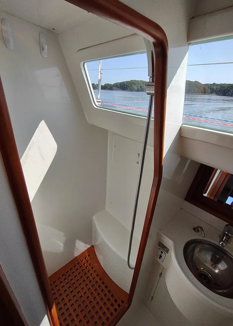 Slide: The Image of Compact bathroom on 2007 Outbound 46 yacht with window view and wooden accents. - 40