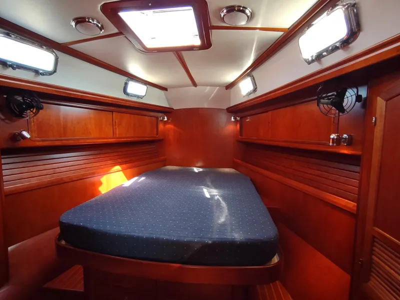 Slide: The Image of Luxurious cabin interior of 2007 Outbound 46 yacht with wooden finish and cozy bed. - 49
