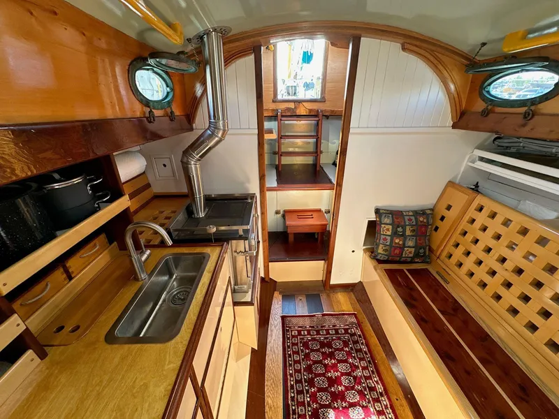 Slide: The Image of Interior of 1947 William Garden 36 Custom Yawl, featuring wood finishes and compact kitchen. - 2
