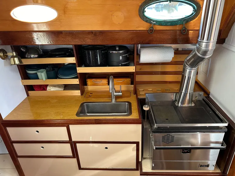 Slide: The Image of Vintage 1947 William Garden 36 Custom Yawl galley with sink, stove, and storage shelves. - 3