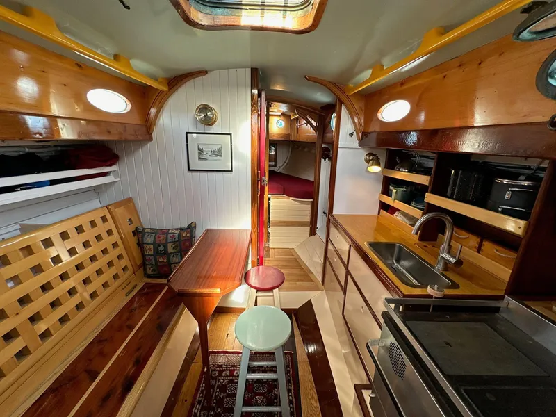 Slide: The Image of Interior of 1947 William Garden 36 Custom Yawl, featuring wood finishes and compact kitchen. - 5