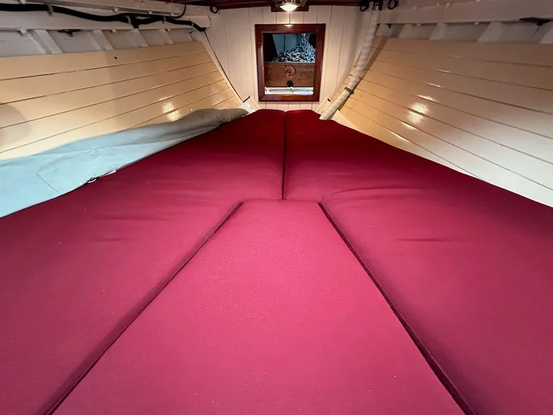 Slide: The Image of Interior of 1947 William Garden 36 Custom Yawl with red cushions and wooden paneling. - 7