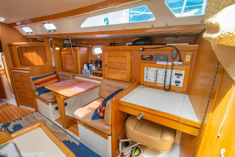 Slide: The Image of Interior of a 2002 Catalina 36 MkII sailboat, featuring a cozy dining area and navigation station. - 15