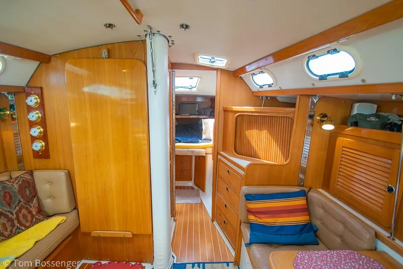 Slide: The Image of Interior of a 2002 Catalina 36 MkII sailboat, featuring wood paneling and cozy seating. - 22
