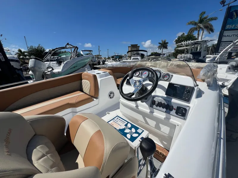 Slide: The Image of 2024 NauticStar 193SC Sport Deck boat interior with steering wheel and seating. - 1