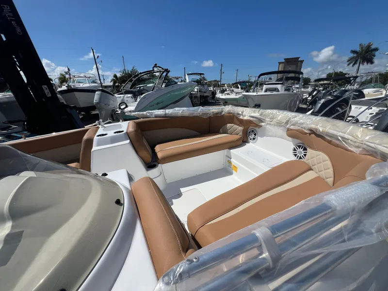 Slide: The Image of 2024 NauticStar 193SC Sport Deck boat with tan seating, docked under clear blue sky. - 2