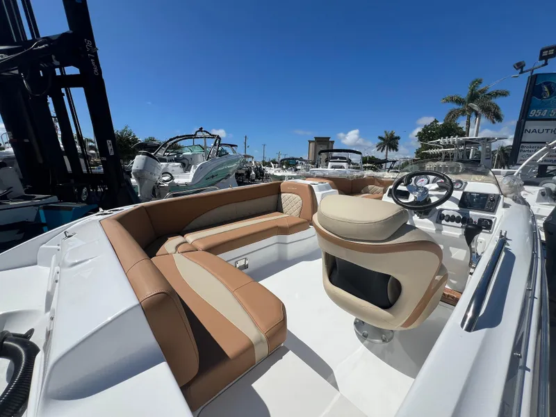 Slide: The Image of 2024 NauticStar 193SC Sport Deck boat interior with tan seating and steering wheel. - 3