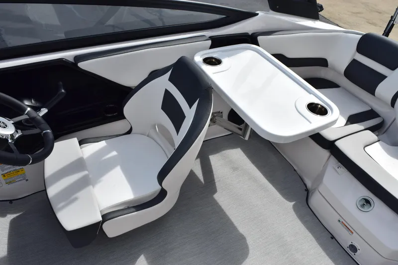 Slide: The Image of 2025 Yamaha Boats AR195 interior with white seating and table, featuring cup holders. - 12