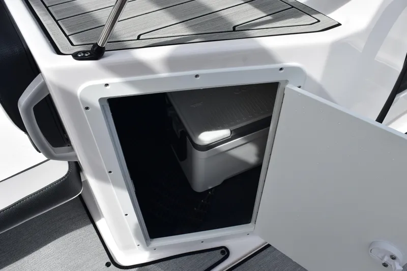 Slide: The Image of 2025 Yamaha AR195 boat storage compartment with open door, revealing interior space. - 16