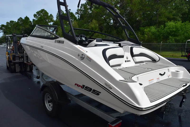 Slide: The Image of 2025 Yamaha Boats AR195 on trailer, sleek design, white exterior, ready for water adventures. - 5