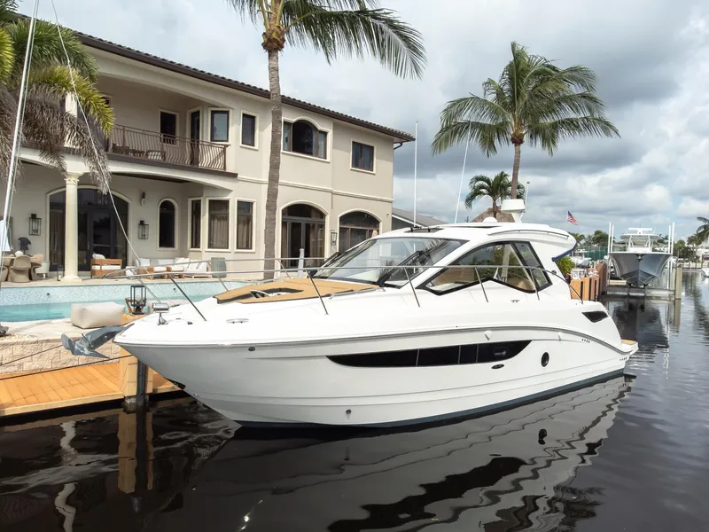 The Image of 2019 Sea Ray Sundancer 350 Coupe docked by a luxurious waterfront home. - 1