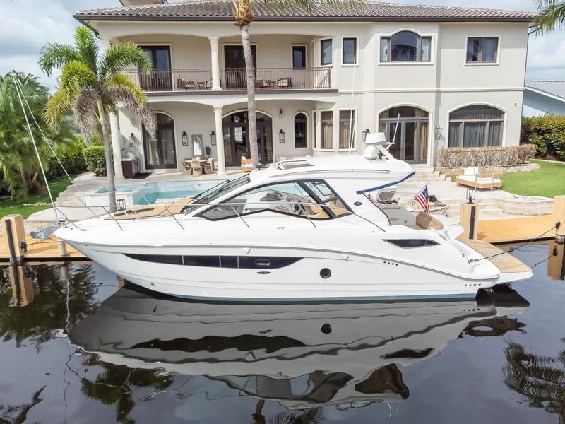 Slide: The Image of 2019 Sea Ray Sundancer 350 Coupe docked by luxurious waterfront home. - 10