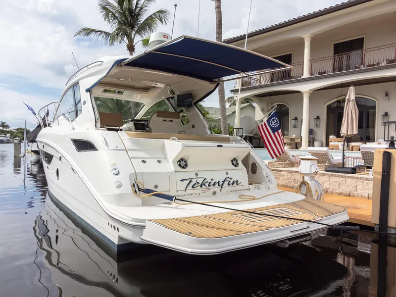Slide: The Image of 2019 Sea Ray Sundancer 350 Coupe docked by a luxurious waterfront home. - 14