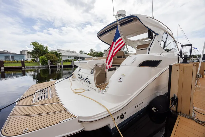 Slide: The Image of 2019 Sea Ray Sundancer 350 Coupe docked with American flag, rear view. - 18