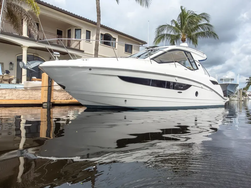 Slide: The Image of 2019 Sea Ray Sundancer 350 Coupe docked by waterfront home. - 2