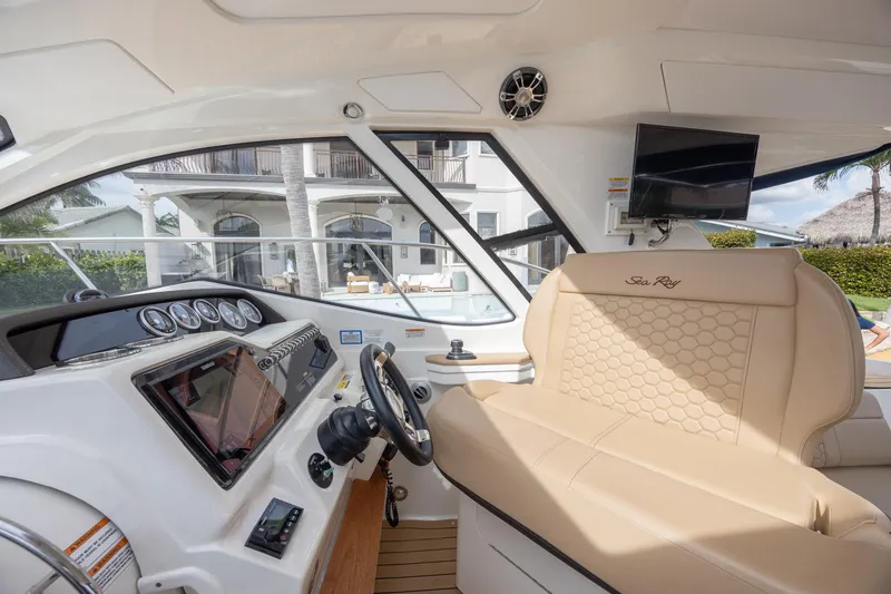 Slide: The Image of 2019 Sea Ray Sundancer 350 Coupe cockpit with luxurious seating and modern dashboard. - 26