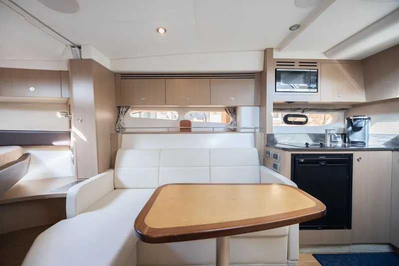 Slide: The Image of Interior of 2019 Sea Ray Sundancer 350 Coupe, featuring modern kitchen and seating area. - 43