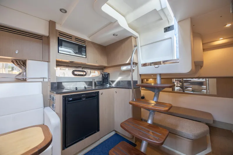 Slide: The Image of 2019 Sea Ray Sundancer 350 Coupe interior with modern kitchen and wooden staircase. - 44