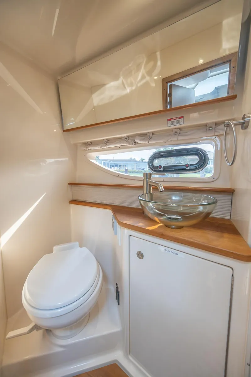 Slide: The Image of 2019 Sea Ray Sundancer 350 Coupe bathroom with modern glass sink and porthole window. - 47