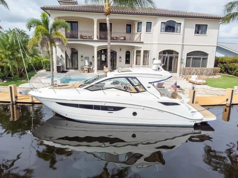 Slide: The Image of 2019 Sea Ray Sundancer 350 Coupe docked by a luxurious waterfront home. - 9