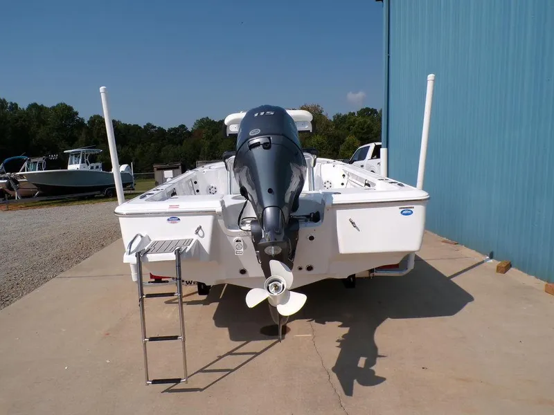 Slide: The Image of 2025 Tidewater 1910 Bay Max boat with outboard motor and ladder, docked outdoors. - 13