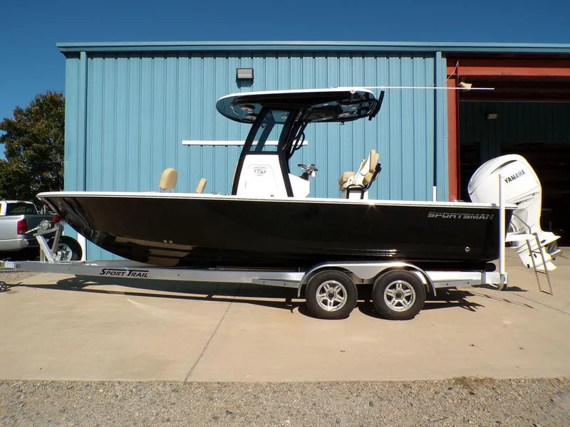The Image of 2025 Sportsman Masters 247 boat on trailer, parked outside a blue building. - 0
