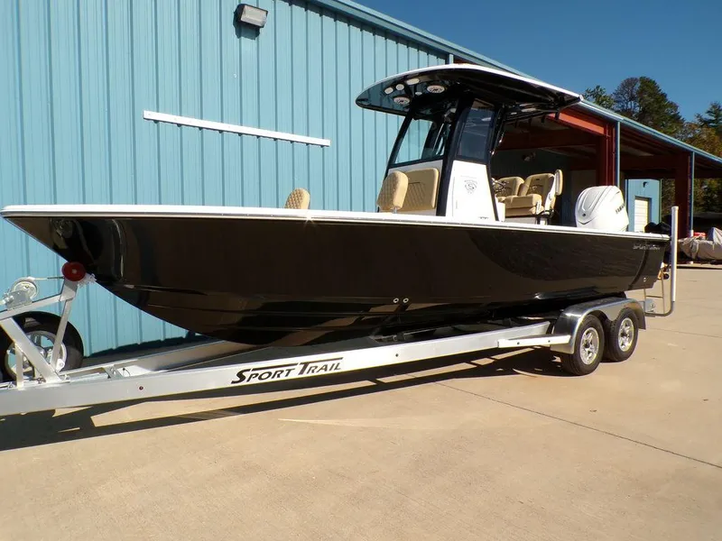 Slide: The Image of 2025 Sportsman Masters 247 boat on trailer, parked outside a blue building. - 1