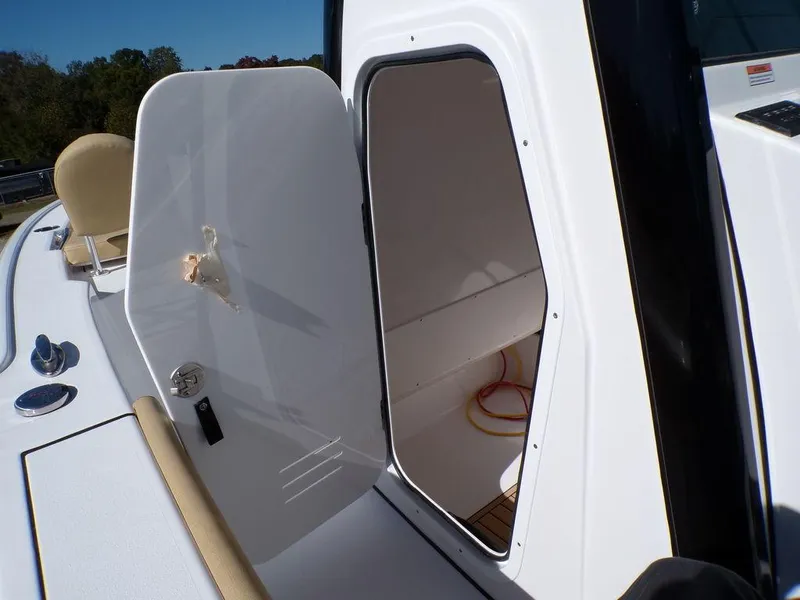 Slide: The Image of 2025 Sportsman Masters 247 boat storage compartment with open door, showcasing interior space. - 13