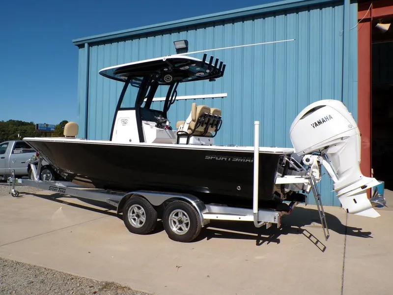 Slide: The Image of 2025 Sportsman Masters 247 boat with Yamaha engine on trailer, parked outside blue building. - 2