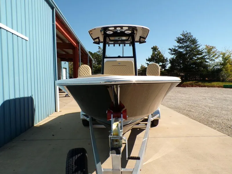 Slide: The Image of 2025 Sportsman Masters 247 boat on trailer, parked near blue building under clear sky. - 4