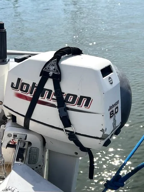 Slide: The Image of Johnson 8.0 outboard motor on 1998 Tartan 4100 sailboat, docked by water. - 21