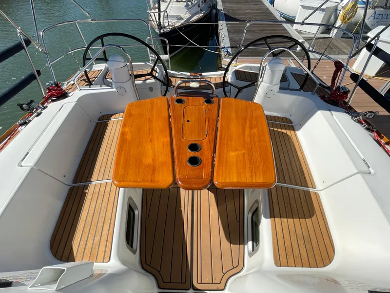 Slide: The Image of Cockpit of 2008 Jeanneau 39i sailboat with dual steering wheels and wooden table. - 13