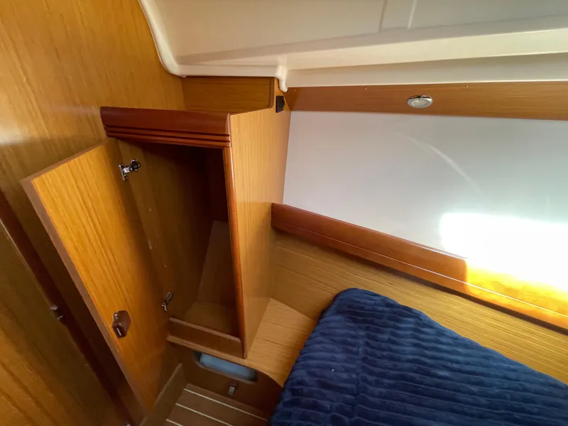Slide: The Image of Interior cabin of 2008 Jeanneau 39i sailboat with wooden storage and blue bedding. - 22