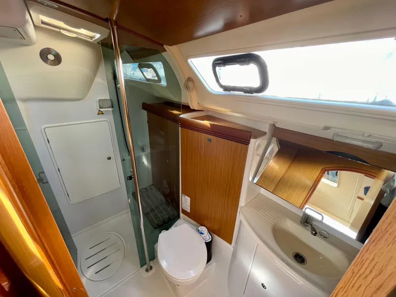 Slide: The Image of 2008 Jeanneau 39i yacht bathroom with shower, toilet, sink, and wooden cabinetry. - 26