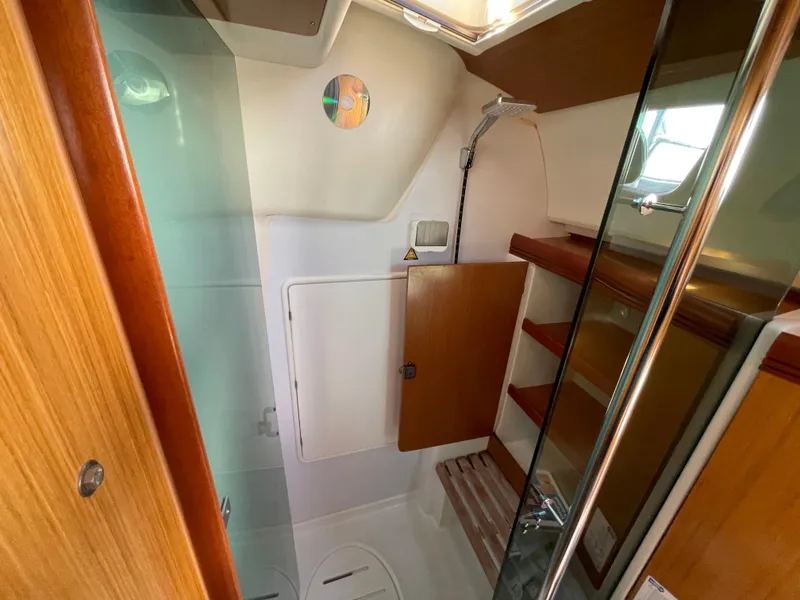 Slide: The Image of 2008 Jeanneau 39i yacht interior bathroom with wooden shelves and glass door. - 27