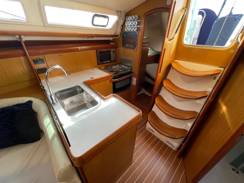 Slide: The Image of Interior of 2008 Jeanneau 39i sailboat with kitchen, sink, and wooden cabinetry. - 29