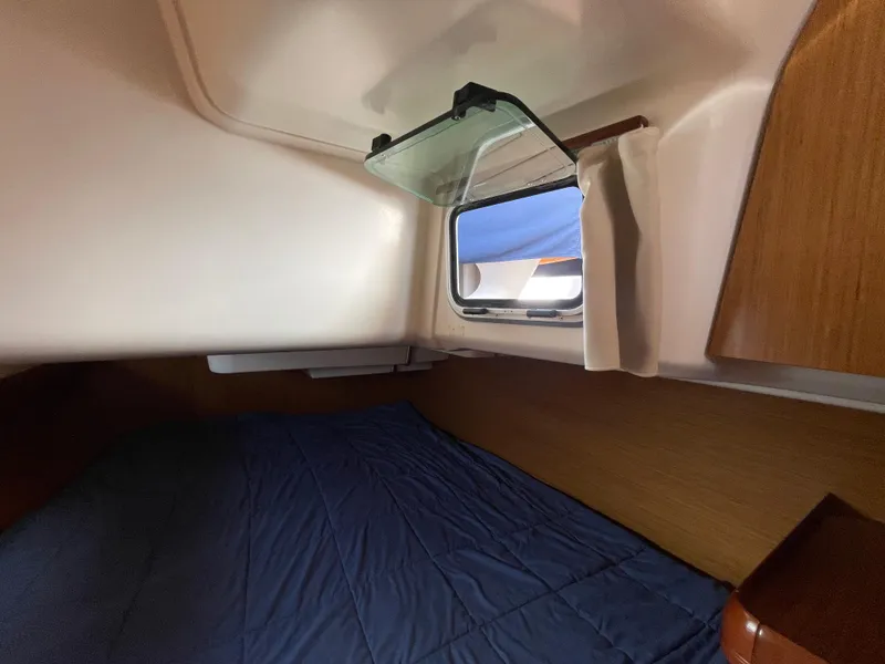 Slide: The Image of Cozy cabin interior of 2008 Jeanneau 39i sailboat with window and blue bedding. - 32