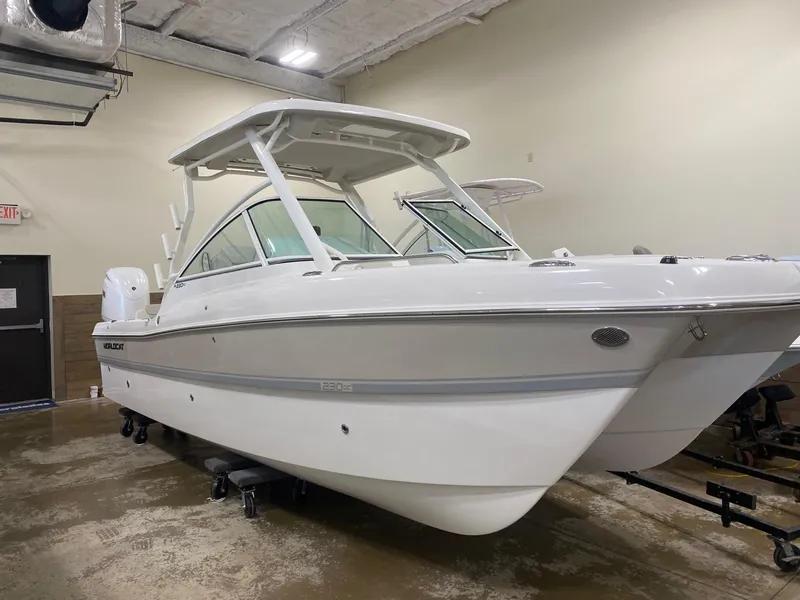 Slide: The Image of 2025 World Cat 230DC boat in showroom, white exterior, dual console design. - 3