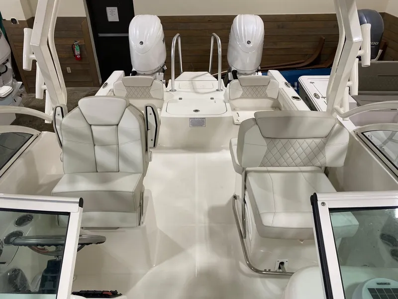 Slide: The Image of 2025 World Cat 230DC boat interior with white seating and dual engines. - 7