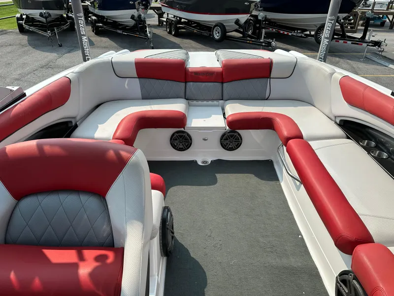 Slide: The Image of 2012 MasterCraft X45 boat interior with red and gray seating, cup holders, and speakers. - 17