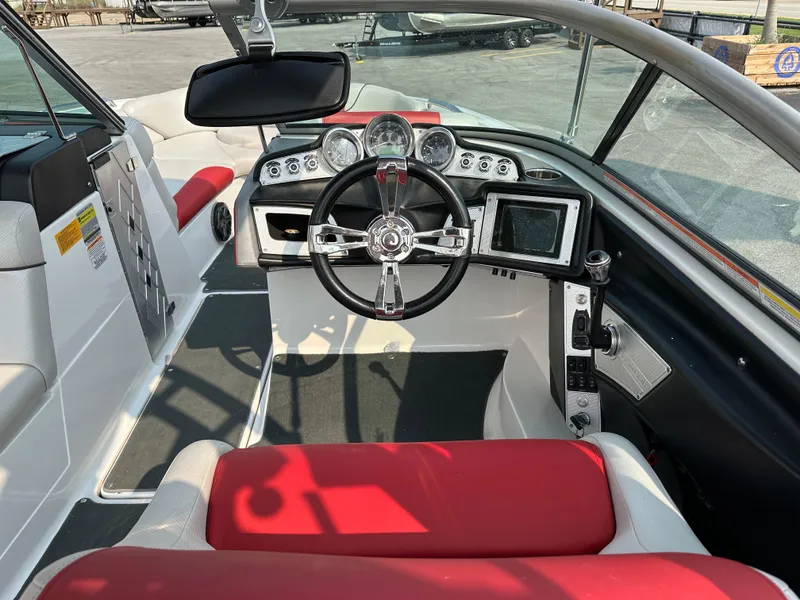 Slide: The Image of 2012 MasterCraft X45 boat interior with red and white seating, steering wheel, and dashboard controls. - 21
