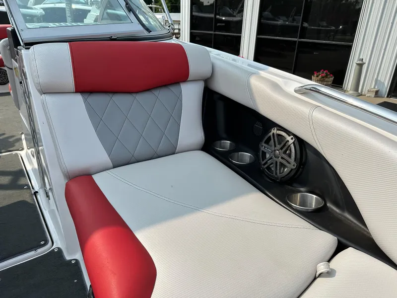 Slide: The Image of 2012 MasterCraft X45 boat interior with red and gray seating, cup holders, and speaker. - 25