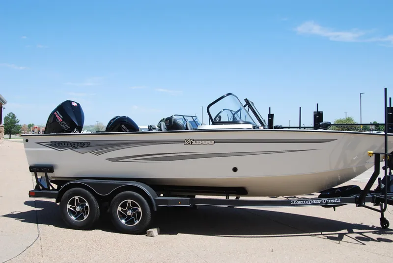 Slide: The Image of 2024 Ranger VX1988 WT boat on trailer, side view, outdoors under clear blue sky. - 0