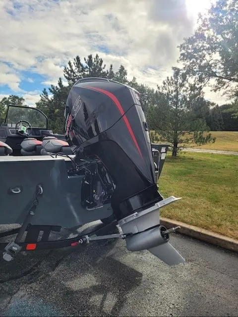 Slide: The Image of 2024 Ranger VX1988 WT boat engine, parked outdoors on a sunny day. - 2