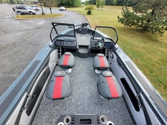 Slide: The Image of 2024 Ranger VX1988 WT boat interior with four seats, gray and red design, parked outdoors. - 4