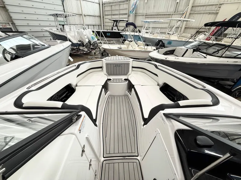 Slide: The Image of 2025 Yamaha Boats 252SD interior, showcasing sleek seating and modern design in a showroom. - 6