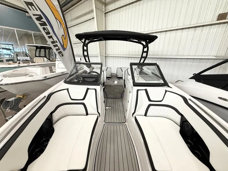 Slide: The Image of 2025 Yamaha Boats 252SD interior with sleek white seating and modern design in showroom. - 7