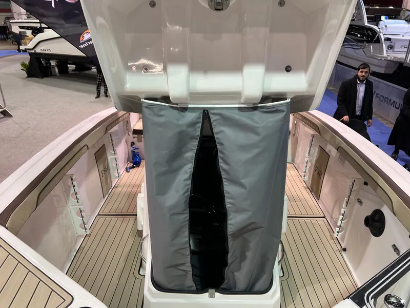 Slide: The Image of 2025 Yamaha Boats 255 FSH Sport H with open storage compartment at a boat show. - 11