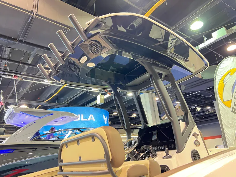 Slide: The Image of 2025 Yamaha Boats 255 FSH Sport H at indoor boat show, featuring sleek design and advanced controls. - 12