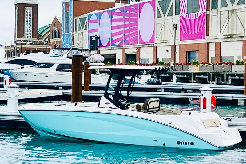 Slide: The Image of 2025 Yamaha Boats 255 FSH Sport H docked in a vibrant marina setting. - 2